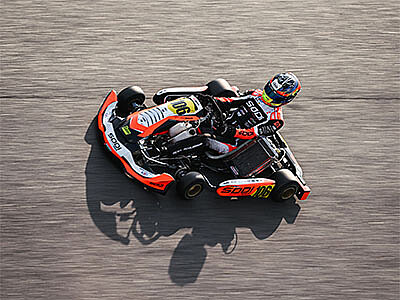 Maximilian Schleimer in einem orange-schwarzen Sodi-Kart fährt auf einer Rennstrecke.